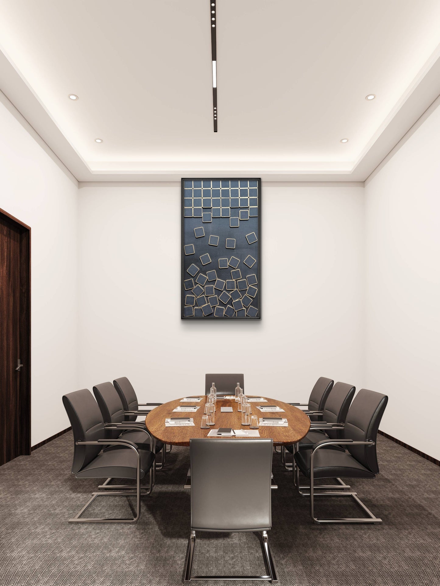 Modern conference room with round wooden table and gray chairs, featuring a wall art piece.