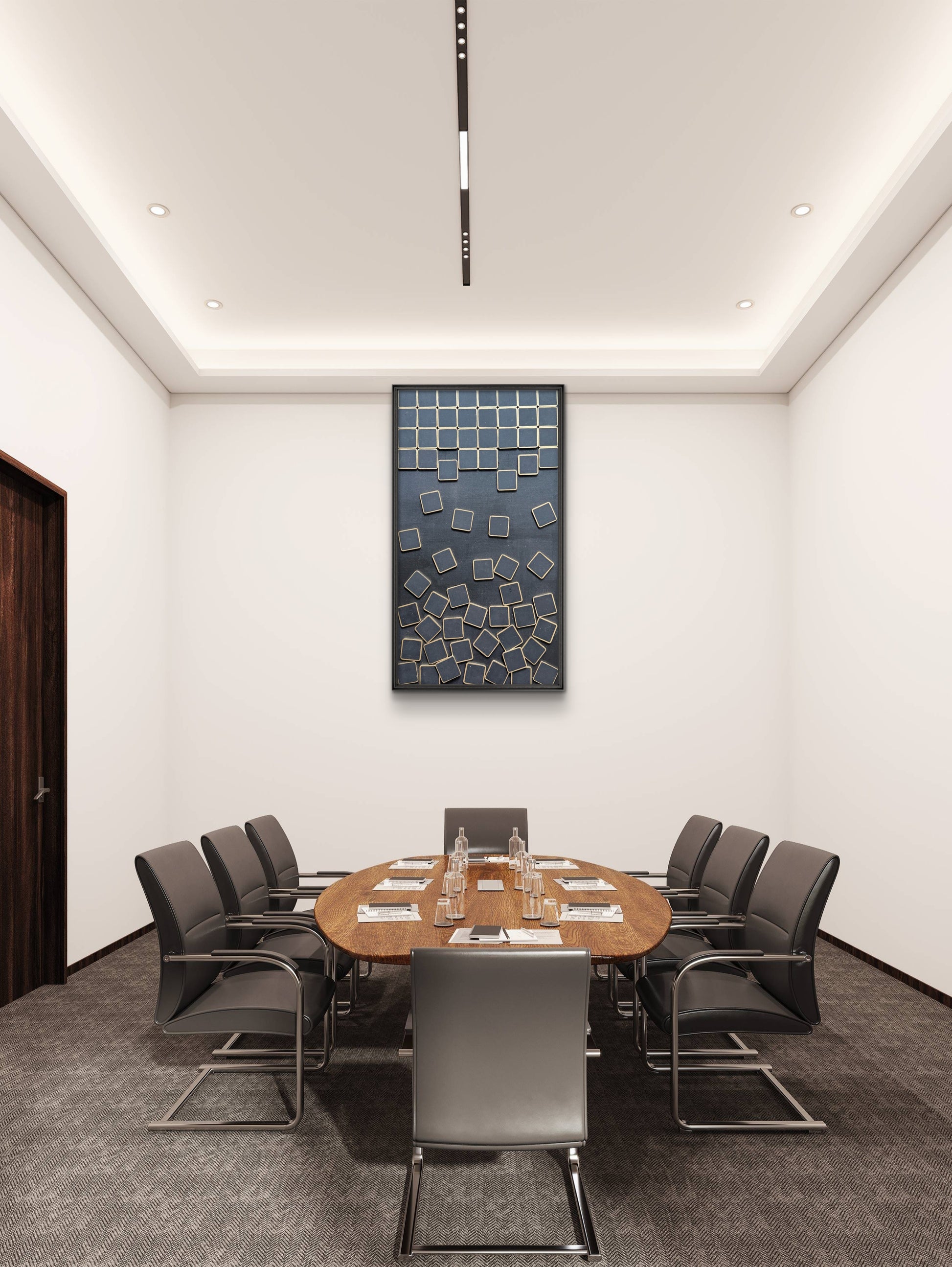 Modern conference room with round wooden table and gray chairs, featuring a wall art piece.