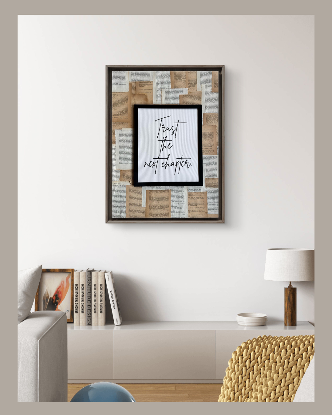Mixed media wall frame with motivational quote and layered torn book pages in neutral tones.